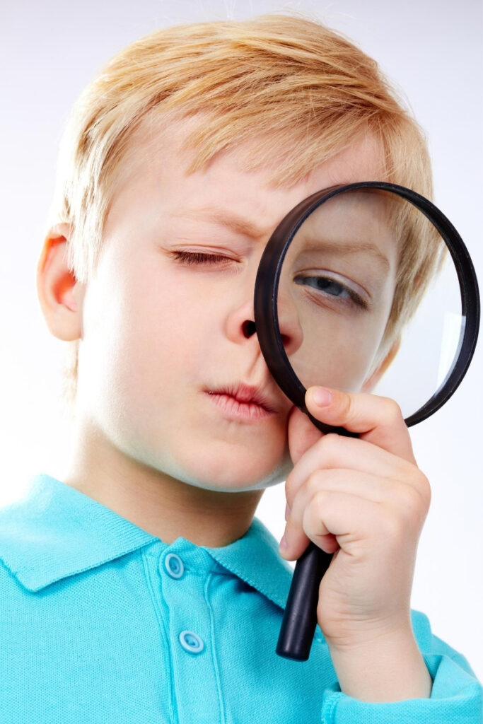 boy looking with magnifying glass as part of a germ hunt