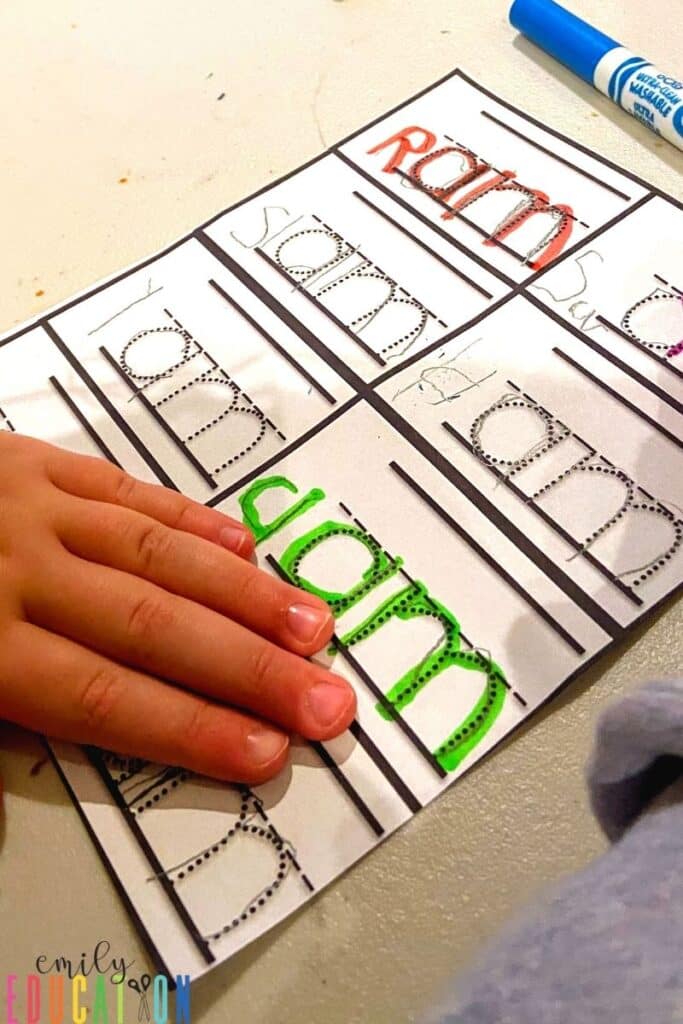 student practices writing word family words with craft activity